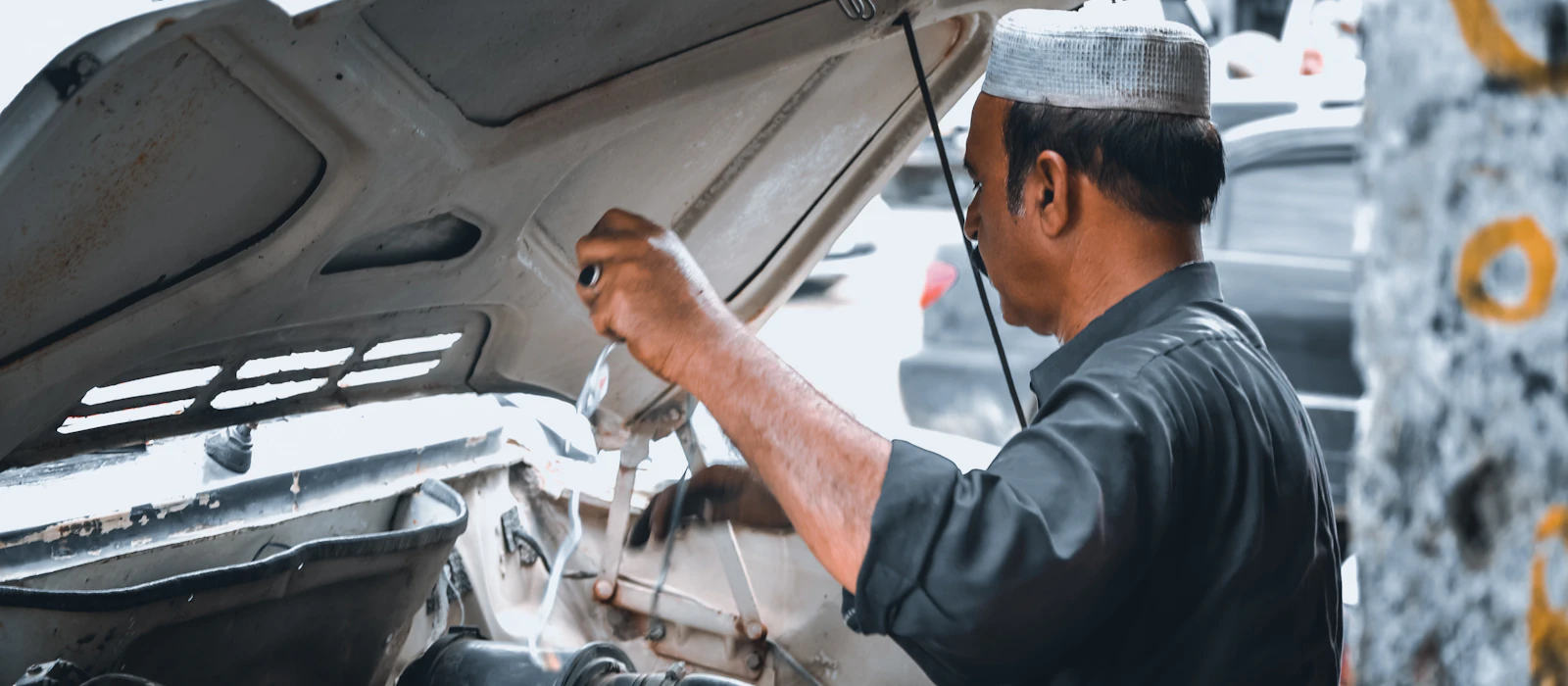 Auto electrician repairing a vehicle in a workshop